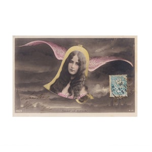 Pode incluir: Postal vintage com um retrato de mulher em forma de sino, com asas cor-de-rosa e um selo. O fundo é um céu escuro e nublado. O texto inclui as palavras "Voyage de Cloches".