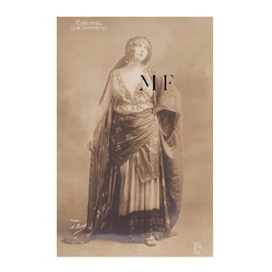 Peut inclure: Photographie vintage en sépia d'une femme en costume élaboré. L'image présente le texte "CHEMAL (La Sorcière)" en haut. La femme porte un diadème orné de bijoux, une robe fluide et un châle. La photo est signée "Photo. A. Bert" en bas.