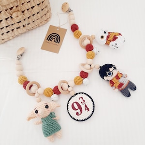 Peut inclure: Un jouet en bois pour bébé avec des personnages en crochet de la série Harry Potter. Le jouet comprend un Dobby en crochet, Harry Potter, Hedwig et un panneau de la plateforme 9 3/4. Le jouet est fait de perles de bois naturel et de personnages en crochet en rouge, jaune, blanc et vert.