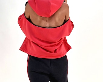 Peut inclure: Un sweat-shirt à capuche rouge avec un design d'épaule découpée et un short noir. Le mannequin porte des baskets à plateforme noires.