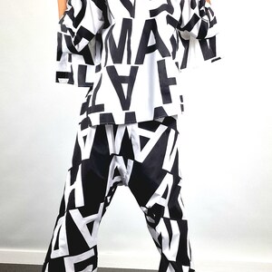 May include: A black and white patterned shirt and trousers set. The shirt has a long sleeve and a relaxed fit. The trousers are wide-legged and have a high waist.