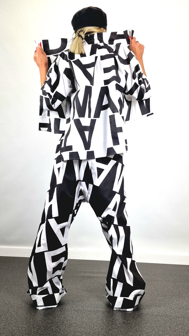 May include: A black and white patterned shirt and trousers set. The shirt has a long sleeve and a relaxed fit. The trousers are wide-legged and have a high waist.