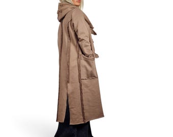 Gedeconstrueerde jas met capuchon, zichtbare naden, avant-garde katoenen duster met rafelige randen.