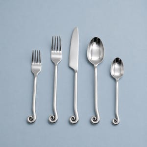 May include: A five-piece stainless steel cutlery set comprising a small fork, a large fork, a dinner knife, a large spoon, and a small spoon. Each item has a polished silver finish and a handle that terminates in a curled spiral design feature.