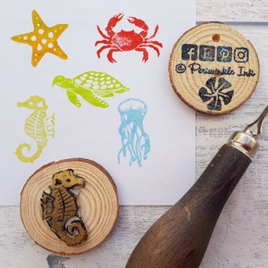 May include: A set of six rubber stamps featuring various sea creatures, including a starfish, crab, turtle, jellyfish, and a seahorse. The stamps are mounted on wooden blocks and are ready to be used for crafting and scrapbooking.