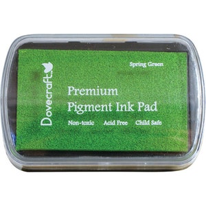 May include: A green Dovecraft Premium Pigment Ink Pad with the text "Spring Green" and "Non-toxic, Acid Free, Child Safe".