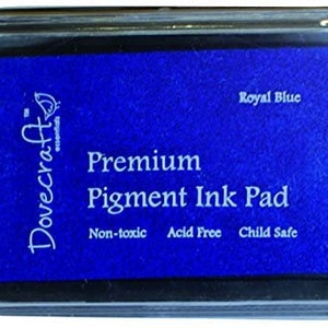 May include: A blue Dovecraft Essentials Premium Pigment Ink Pad in a clear plastic case. The ink pad is labeled "Royal Blue", "Non-toxic", "Acid Free", and "Child Safe".