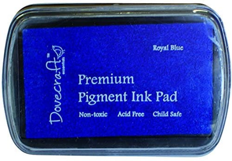 May include: A blue Dovecraft Essentials Premium Pigment Ink Pad in a clear plastic case. The ink pad is labeled "Royal Blue", "Non-toxic", "Acid Free", and "Child Safe".