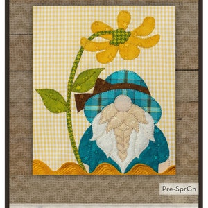 May include: Spring Gnome applique pattern with a yellow flower, green leaves, and a blue gnome with a plaid hat. The pattern is 7 1/2 inches by 9 inches.