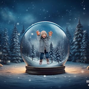 May include: A child wearing a blue coat and orange mittens stands inside a snow globe. The snow globe is surrounded by a snowy forest with pine trees. The snow globe is on a wooden base.