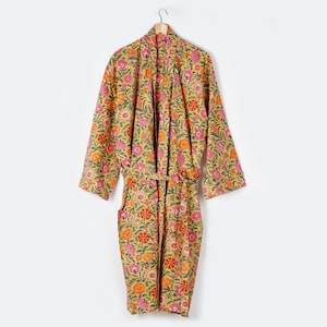 May include: A yellow floral print robe with a pink and orange floral pattern. The robe has a tie belt and long sleeves.