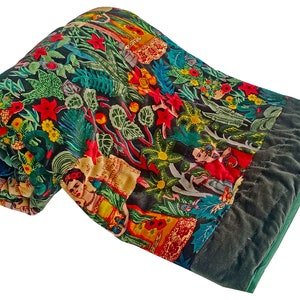 Könnte beinhalten: Eine grüne, rote und gelbe, floral gemusterte Steppdecke mit einem dunkelgrünen Samt-Rand. Die Steppdecke ist in der Hälfte gefaltet und das Muster zeigt eine Vielzahl von Blumen, Pflanzen und Menschen.