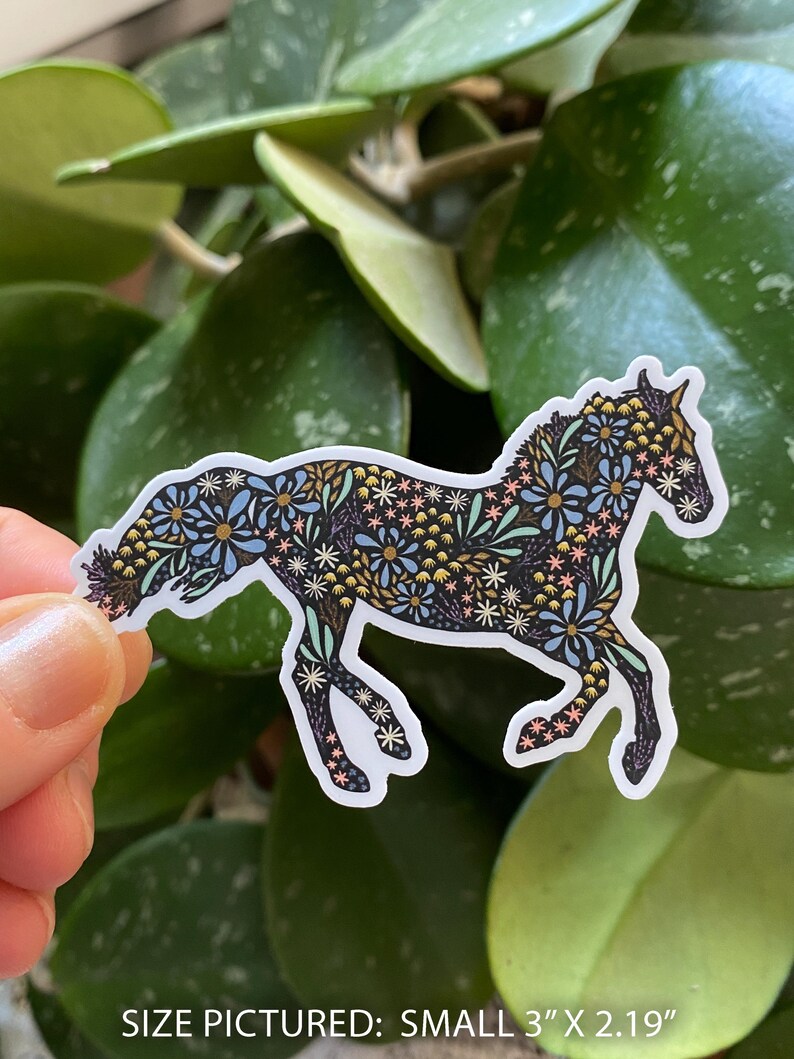 May include: A sticker featuring a horse silhouette filled with a floral pattern in blue, yellow, and white. The sticker is approximately 3 inches by 2.19 inches. The horse is depicted in a running pose, with a white border.