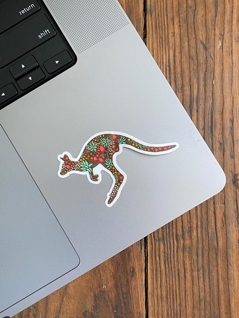 May include: A sticker of a kangaroo with a floral pattern in shades of brown, green, red, and white. The kangaroo is in a jumping pose.
