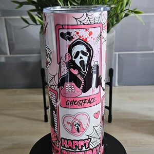 May include: Pink and black stainless steel tumbler with a graphic of Ghostface from the Scream movie franchise. The tumbler has a pink background with black spiderwebs and the text "Happy Birthday Rachel" and "Ghostface".