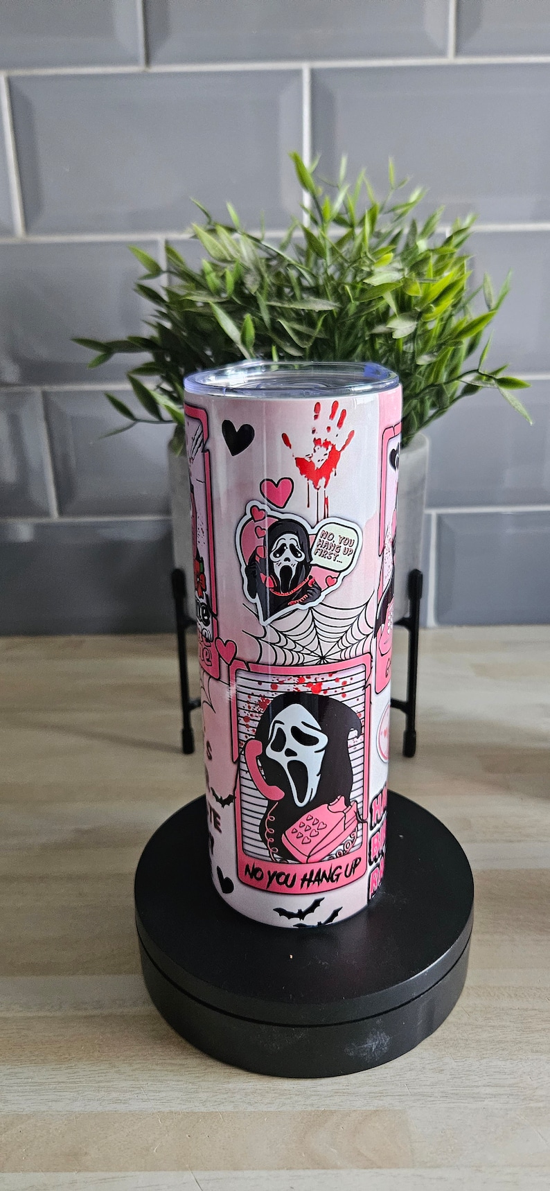 May include: Pink and black stainless steel tumbler with a graphic of a ghost wearing a mask and holding a phone. The text on the tumbler says "No you hang up first..." and "No you hang up".