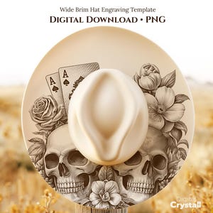 Puede incluir: Un sombrero de ala ancha crema, con un grabado detallado de dos calaveras, naipes y elementos florales. El sombrero es una descarga digital en formato PNG.