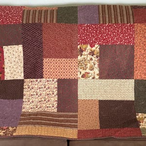 May include: A set of three ceramic mugs with a speckled, matte finish. The mugs are in shades of cream, light gray, and dark gray. Each mug has a simple, minimalist design, perfect for coffee or tea.