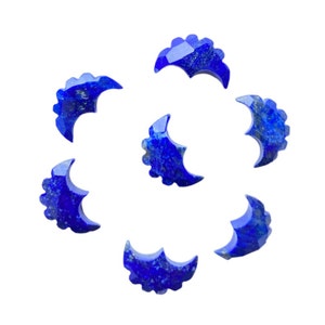May include: Seven blue crescent moon shaped lapis lazuli stones with a scalloped edge.