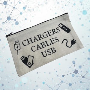 May include: A rectangular, beige canvas pouch with a black zip. The pouch has the words "CHARGERS CABLES USB" in black, with black illustrations of a charger, USB drive, and power plug. The background has a network design.