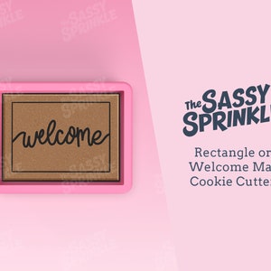 Op de afbeelding: Roze welkommat-koekjesvormpje met de tekst "The Sassy Sprinkle" en "Rectangle or Welcome Mat Cookie Cutter" in zwart.