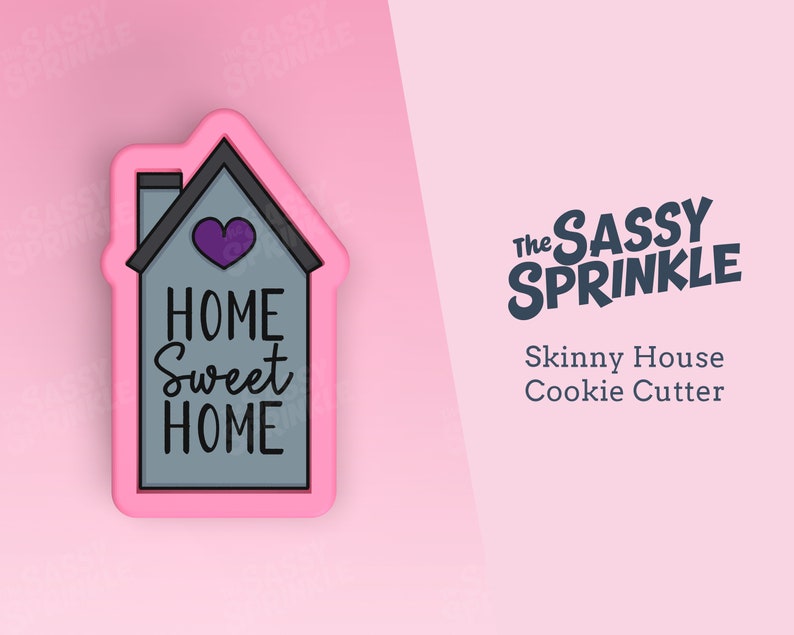 Op de afbeelding: Roze plastic koekjesvormpje in de vorm van een huis met de woorden "Home Sweet Home" en een paars hart. De koekjesvormpje is op een roze achtergrond. De tekst "The Sassy Sprinkle" en "Skinny House Cookie Cutter" is ook zichtbaar.