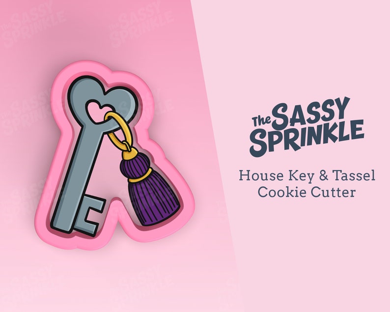 Op de afbeelding: Een roze plastic koekjesvormpje in de vorm van een huissleutel met een paarse kwast. Het koekjesvormpje is op een roze achtergrond. De tekst "The Sassy Sprinkle" en "House Key & Tassel Cookie Cutter" staat op de achtergrond.