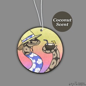 May include: A round car air freshener with a cartoon illustration of a snake wearing a straw hat and a Hawaiian shirt, holding a coconut with a straw. The background is a sunset gradient with yellow, orange, pink, and purple colors. The text "Coconut Scent" is printed on the top of the air freshener.
