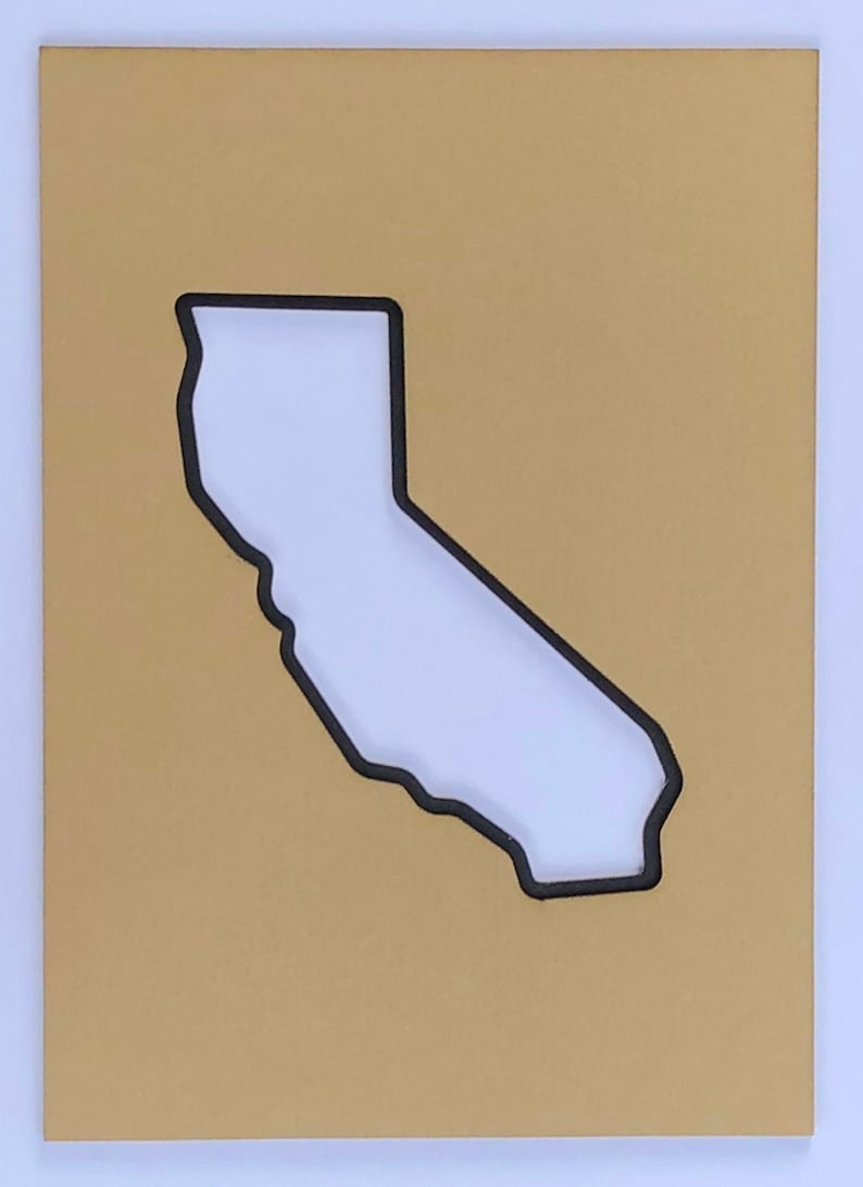 May include: A gold-colored background with a black outline of the state of California cut out of the center.