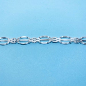 Könnte beinhalten: Ein silbernes Kettenarmband mit einem zarten, verflochtenen Design. Die Kette besteht aus kleinen, ovalen Gliedern, die in einem sich wiederholenden Muster miteinander verbunden sind.