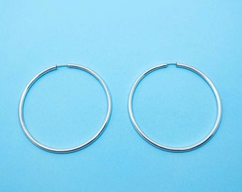 May include: A pair of silver hoop earrings. The earrings are simple and elegant, and they would be a great addition to any jewelry collection.