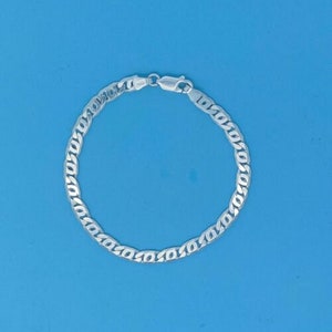 May include: A silver curb chain bracelet with a polished finish.