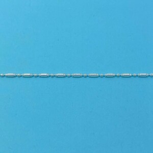 May include: A silver chain necklace with small, round beads and longer, rectangular links.