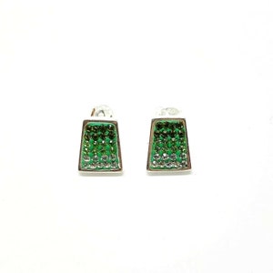 Könnte beinhalten: Ein Paar silberne Ohrringe mit einem Design aus grünen und klaren Kristallen. Die Ohrringe haben die Form eines Rechtecks mit abgerundeten Ecken.