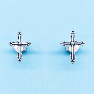 Op de afbeelding: Een paar zilveren kruis oorbel studs. De kruisen zijn versierd met kleine kralen rond de randen.