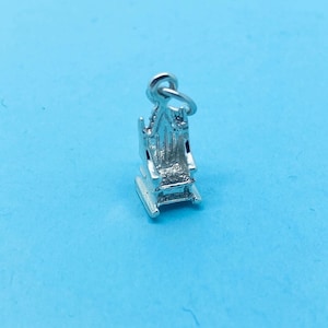 Puede incluir: Encanto de plata en forma de mecedora. La silla tiene un diseño detallado y un bucle en la parte superior para sujetarlo a una pulsera o collar.