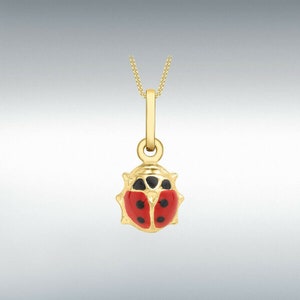 May include: A gold ladybug pendant necklace with red enamel and black accents. The pendant is attached to a gold chain.