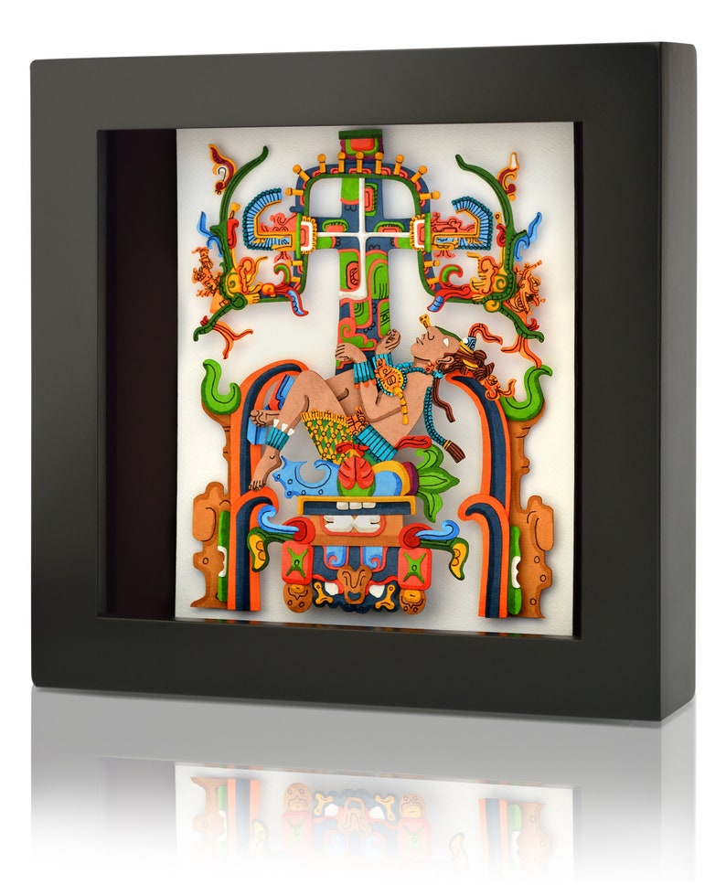 May include: A framed, colorful, 3D paper art piece depicting a reclining figure with a crown, surrounded by intricate designs and symbols. The artwork is set against a white background.
