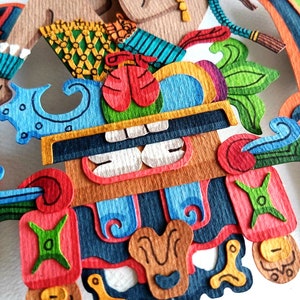 May include: A colorful paper mache sculpture of a mythical creature with a large, toothy mouth. The sculpture is made of layered paper and painted in bright colors, including red, blue, green, and yellow.