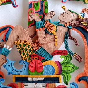 May include: A colorful paper cut-out of a reclining figure with a crown and a feathered headdress. The figure is surrounded by intricate floral designs and geometric patterns.