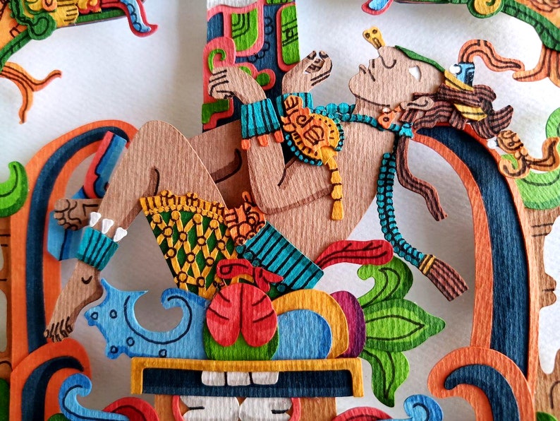 May include: A colorful paper cut-out of a reclining figure with a crown and a feathered headdress. The figure is surrounded by intricate floral designs and geometric patterns.