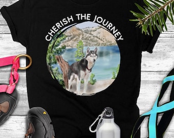 May include: Black t-shirt with a white circle graphic that says "Cherish the Journey". The graphic also features a watercolor illustration of a husky dog in a mountain landscape.