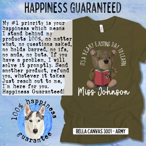 Op de afbeelding: Een groen T-shirt met een bruine beer die een rood boek draagt en een bloem vasthoudt. De tekst "It's a Bear-y Exciting Day to Learn" staat boven de beer en "Miss Johnson" staat onder de beer. De tekst "Bella Canvas 3001 - Army" staat onderaan het T-shirt. De tekst "100% happiness guarantee" staat in een cirkel met een husky-hond erin. De tekst "My #1 priority is your happiness which means I stand behind my products 100%, no matter what, no questions asked, no holds barred, no ifs, no ands, no buts. If you have a problem, I will solve it promptly. Send another product, refund you, whatever it takes Just reach out to me, I'm here for you. Happiness Guaranteed!" staat aan de linkerkant van de afbeelding.