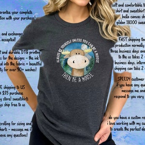 May include: A grey t-shirt featuring a moose illustration and the text "Always be yourself unless you can be a moose, then be a moose".