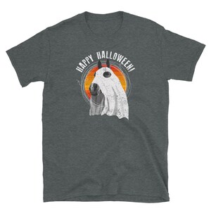 May include: A dark heather grey t-shirt with a graphic of a horse wearing a ghost costume. The text "Happy Halloween!" is printed in white above the horse.