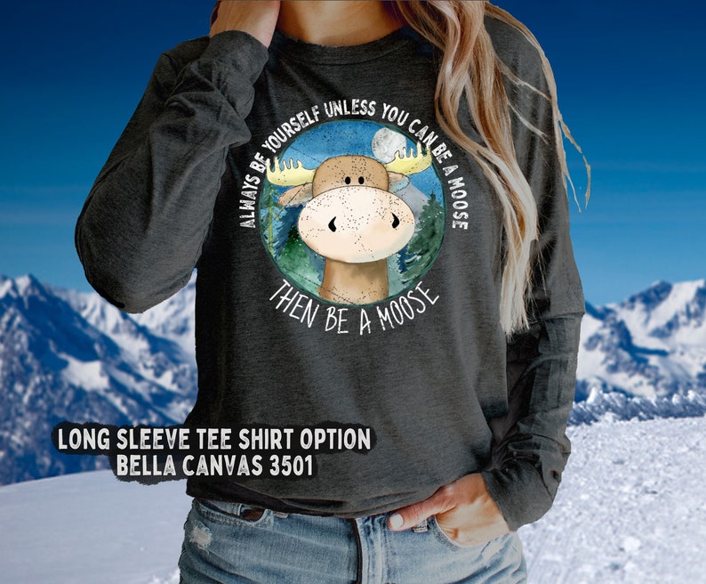 May include: A dark heather grey long-sleeved t-shirt with a cartoon moose graphic and the text "Always be yourself unless you can be a moose, then be a moose".