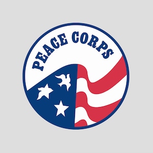 Może przedstawiać: Okrągłe logo w kolorze niebieskim i czerwonym z napisem "PEACE CORPS" w białym kolorze. Logo przedstawia stylizowaną flagę amerykańską z białymi gwiazdami i gołębiem.