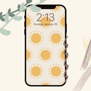 May include: A smartphone with a white background and a pattern of yellow suns. The time is 2:13 and the date is Sunday, January 16.