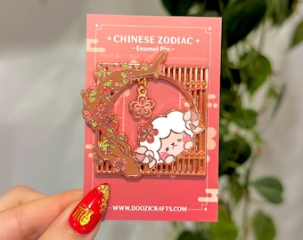 Könnte beinhalten: Eine roségoldene Emaille-Anstecknadel mit einem Cartoon-Schaf in einem Kirschblütenbaum. Die Anstecknadel ist Teil einer chinesischen Tierkreis-Kollektion und enthält den Text "Chinese Zodiac - Enamel Pin - www.doozicrafts.com".