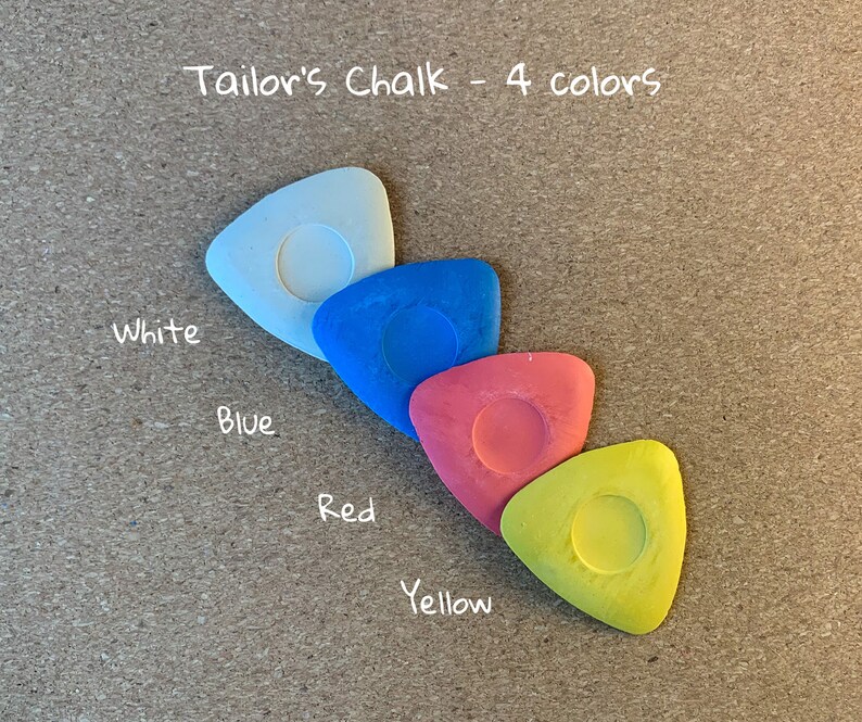 May include: Four tailor's chalk pieces in a triangular shape, arranged in a row from white to blue, red, and yellow. The text "Tailor's Chalk - 4 colors" is written above the chalk pieces.